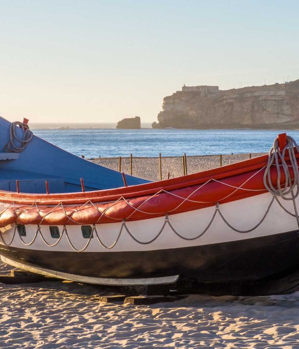 A fishing boat on the beach of Nazare in Portugal during daytime