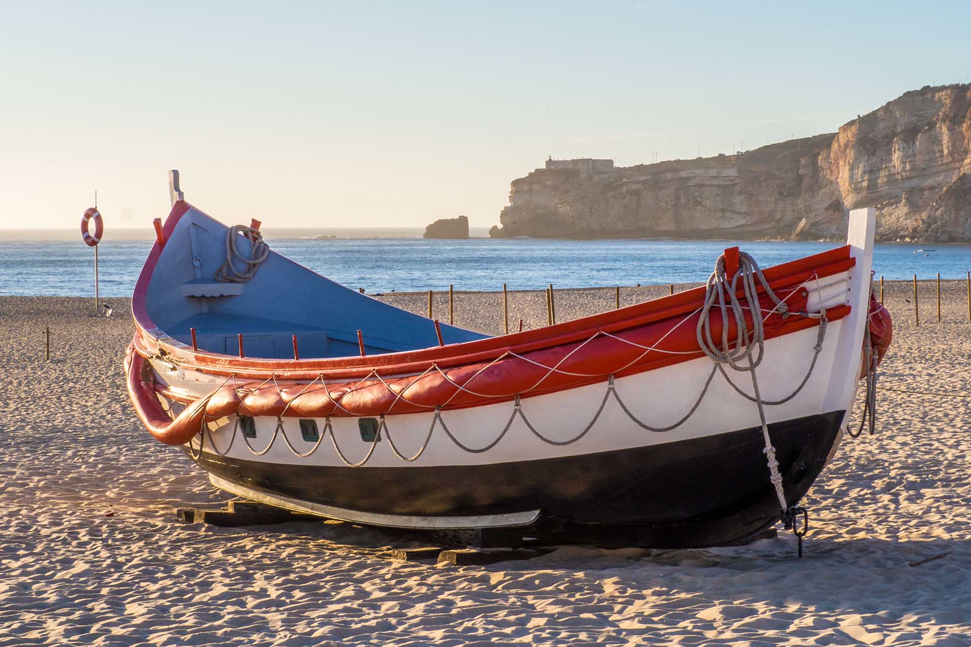 A fishing boat on the beach of Nazare in Portugal during daytime