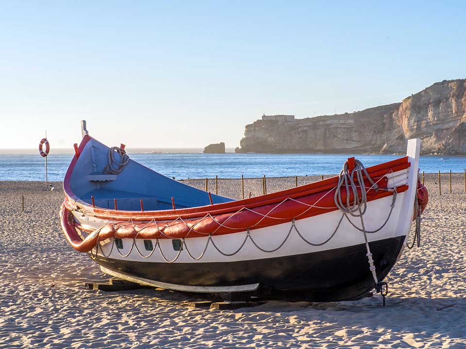 A fishing boat on the beach of Nazare in Portugal during daytime